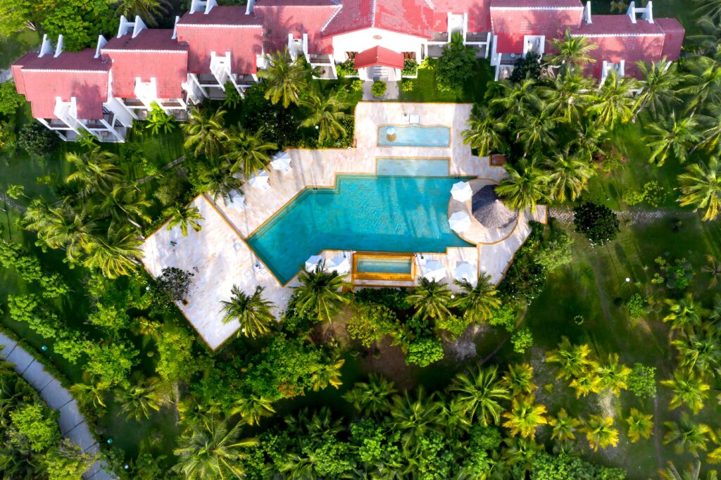 Bird's eye view of tropical resort featuring lush gardens and inviting pool.