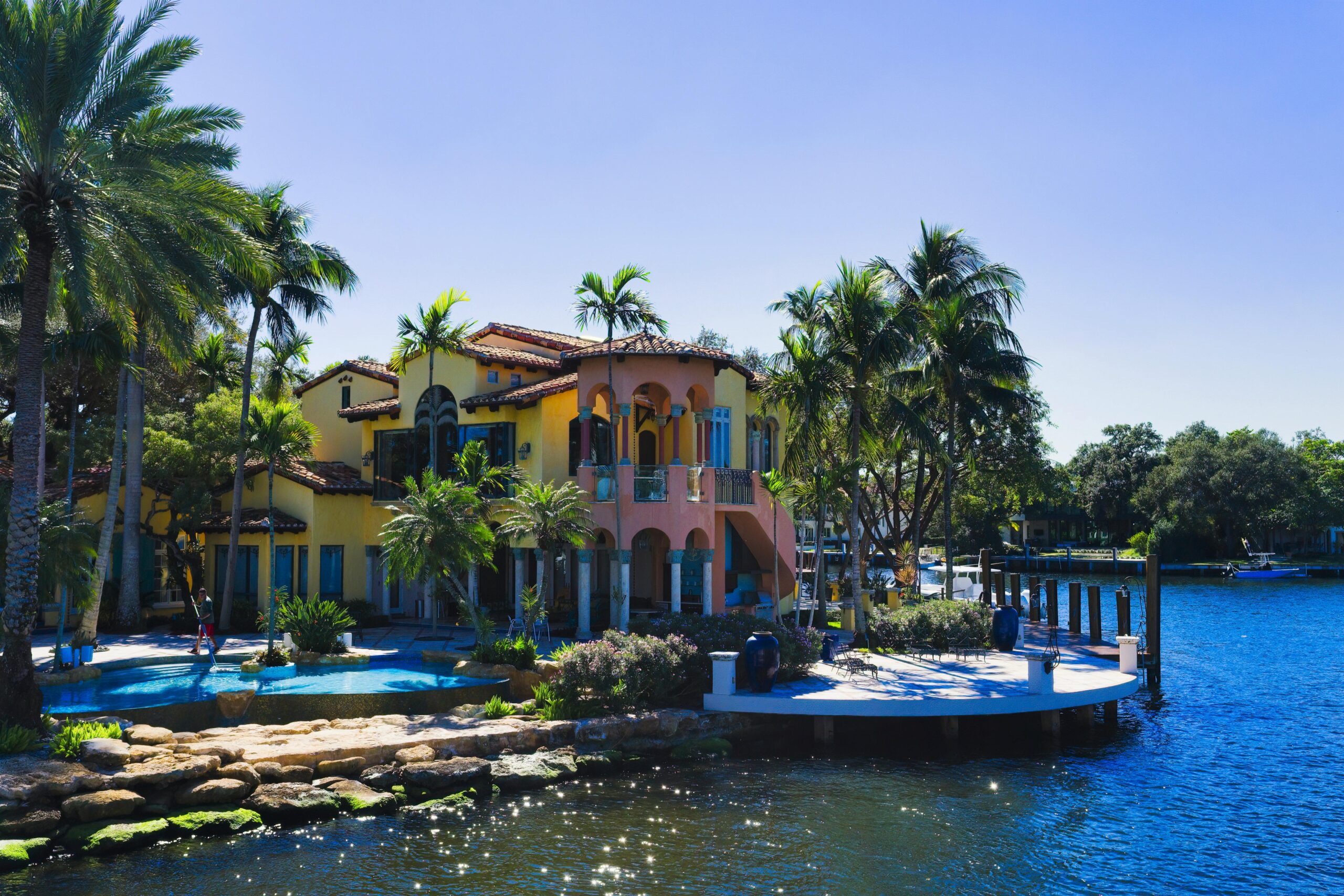 Stunning view of a colorful mansion with palm trees by the water in Fort Lauderdale, Florida.