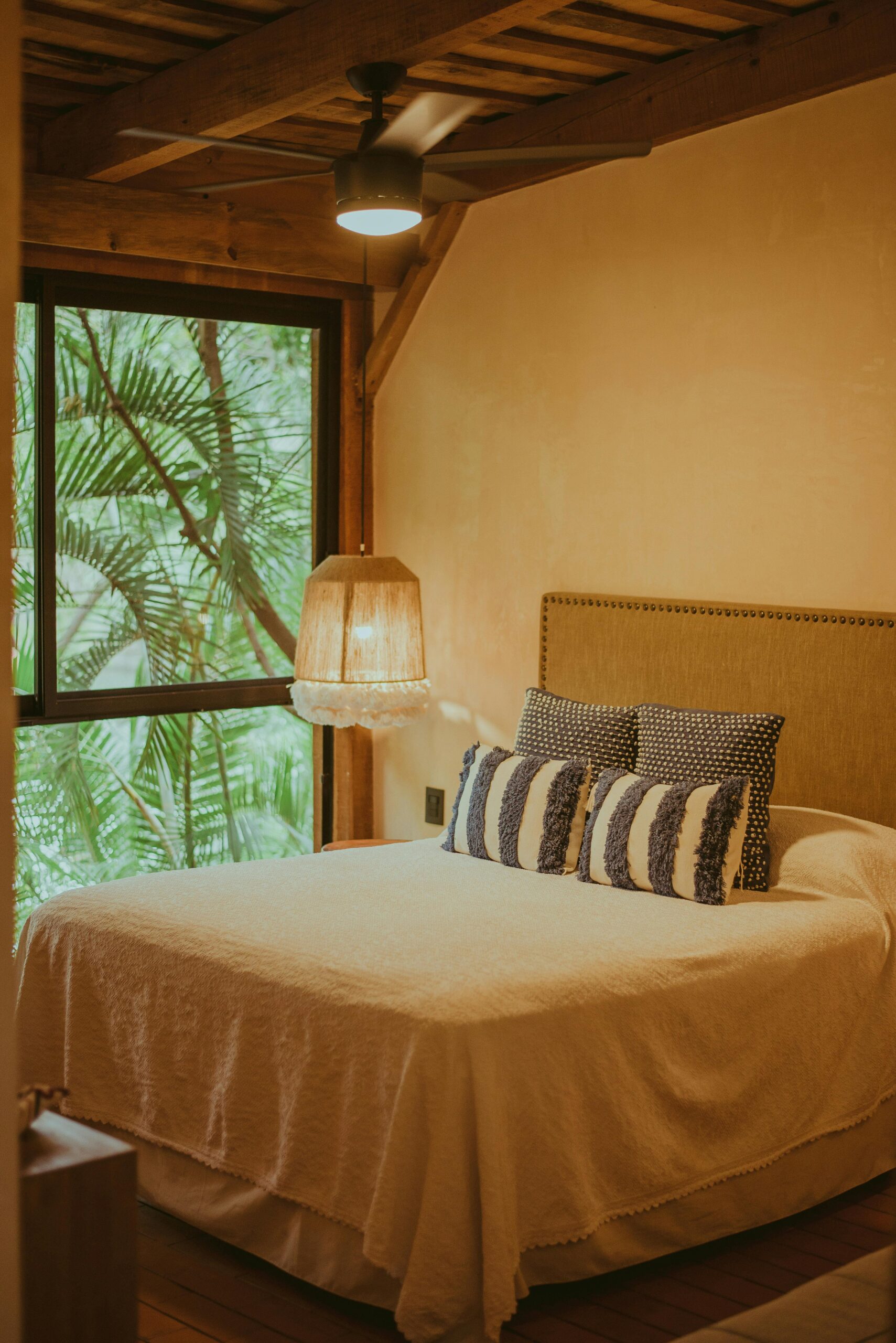 Warm and inviting rustic bedroom interior with natural light and greenery view.