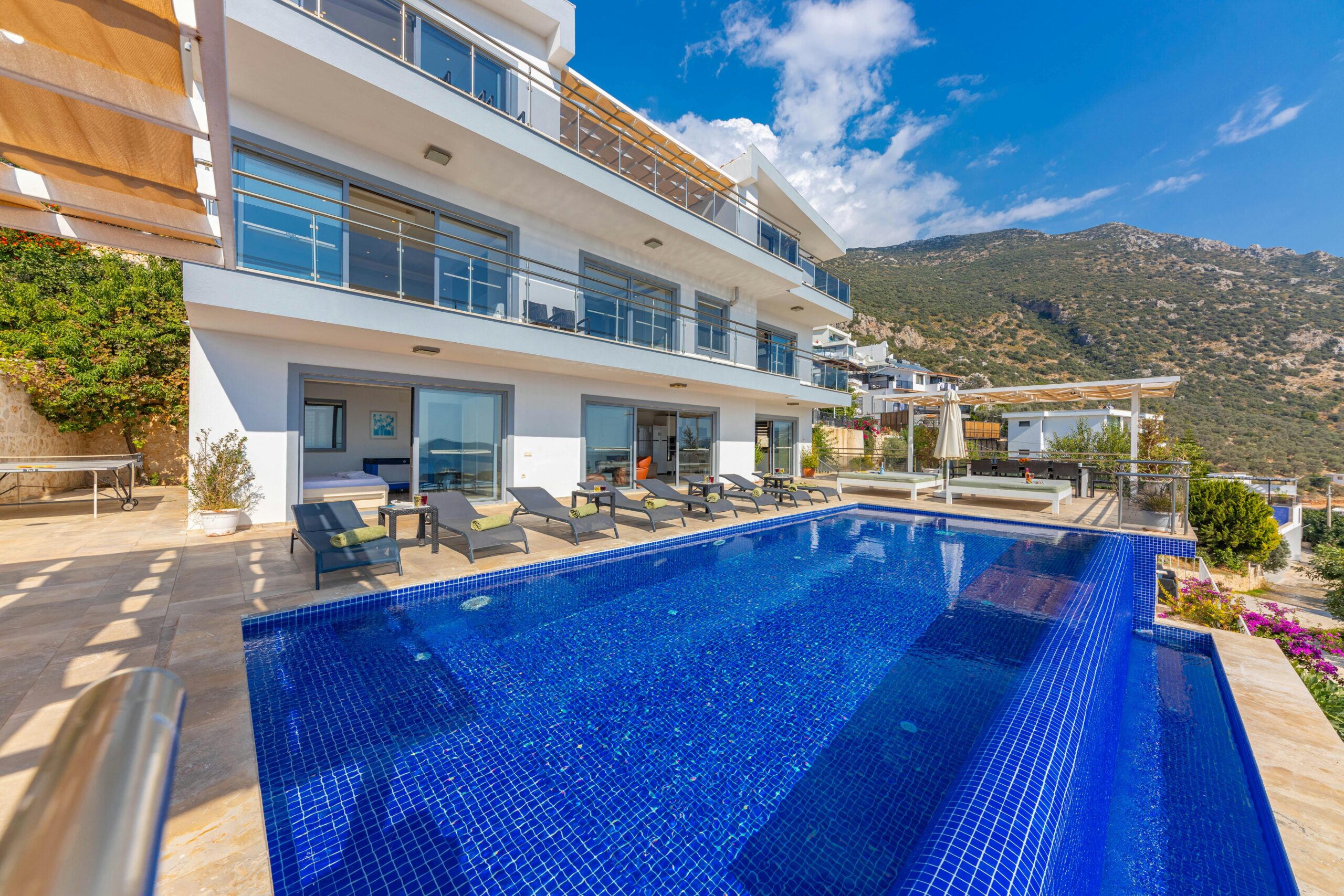 Elegantly designed luxury resort with a swimming pool, set against a stunning mountain backdrop.